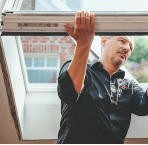 Professionnel qui mesure la dimension d'une fenêtre de toit